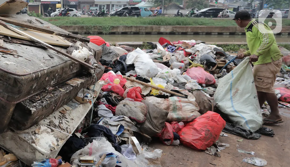 Warga memilah sampah sisa banjir yang menumpuk di kawasan Cipinang Melayu, Jakarta, Rabu (8/1/2020). Banjir yang melanda Jakarta dan sekitarnya sejak 1 Januari 2020 lalu menyisakan tumpukan sampah di sejumlah titik. (Liputan6.com/Herman Zakharia)