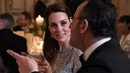 Duchess of Cambridge, Kate Middleton berbincang dengan aktor Perancis Jean Reno selama makan malam di Kedutaan Besar Inggris di Paris, Prancis (17/3). Ini kunjungan resmi pertama Kate dan William ke ibukota Prancis itu. (AFP Photo/Pool/Eric Feferberg)