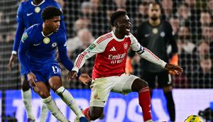 Pemain Arsenal, Bukayo Saja (kanan), mengerang kesakitan saat berduel dengan pemain Chelsea pada semifinal leg pertama Carabao Cup di Stamford Bridge, Kamis (15/1/2026) dini hari WIB. (Ben STANSALL / AFP)