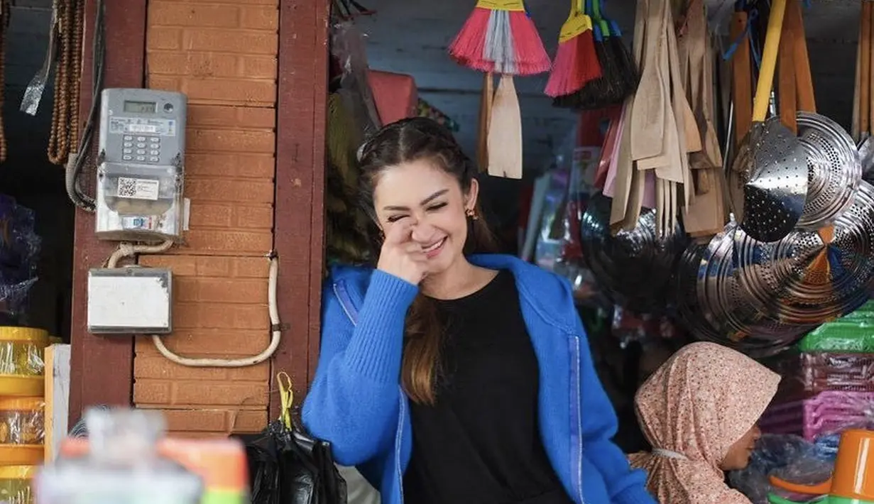 Berfoto di warung kelontong, Nafa mengenakan jaket biru dipadukan t shirt dan celana hitam. Rambutnya pun dikepang dua. Credit (@nafaurbach)