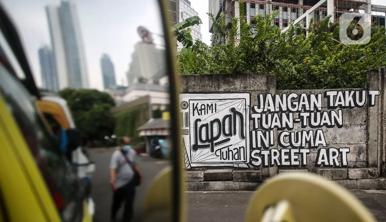 Mural yang bertuliskan “Kami Lapar Tuhan” di kawasan Jakarta Pusat, Selasa (24/8/2021). Banyak beberapa tempat mural yang menyuarakan kebebasan berpendapat saat ini menjadi viral lantaran dihapus oleh petugas. (Liputan6.com/Johan Tallo)