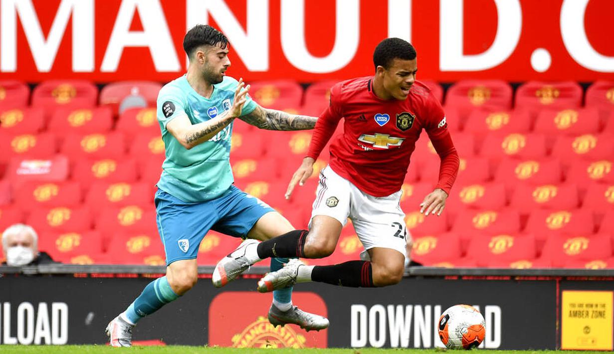 Pemain Manchester United, Mason Greenwood, berebut bola dengan pemain Diego Rico pada laga Premier League di Stadion Old Trafford Sabtu (4/6/2020). Manchester United menang 5-2 atas Bournemouth. (AP/Peter Powell)