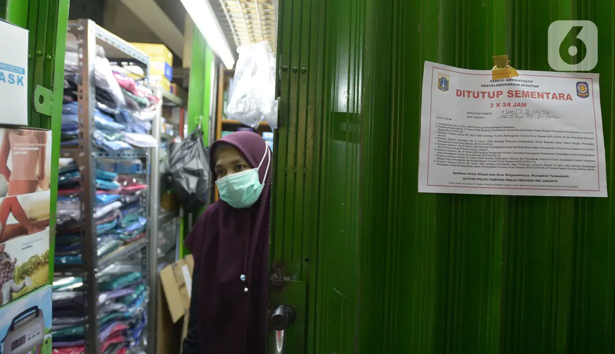 Segel penutupan sementara dipasang di salah satu toko di Pasar Pramuka, Jakarta, Kamis (24/9/2020). Upaya mencegah penularan virus corona terus dilakukan dengan merazia penggunaan masker dan tempat usaha makan yang masih melayani makan di tempat. (merdeka.com/Imam Buhori)