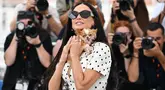 Aktris AS Demi Moore berpose dengan anjing Chihuahua miliknya bernama Pilaf pada sesi pemotretan untuk film "The Substance" di Festival Film Cannes ke-77, Prancis selatan, Senin (20/5/2024). (CHRISTOPHE SIMON / AFP)