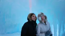 Olha Ratushko dan putrinya Zhenya menjelajahi Kastil Es di Excelsior, Minn (18/1). Kastil tersebut meliputi patung-patung LED-menyala yang menakjubkan, singgasana beku, terowongan pahatan es, seluncuran, air mancur. (Anthony Souffle / Star Tribune via AP)