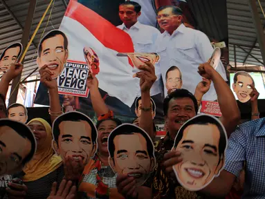 Sejumlah pedagang dan pengunjung mengenakan topeng bergambar Jokowi di Pasar Gede, Solo, (20/10/14). (ANTARA FOTO/Maulana Surya)