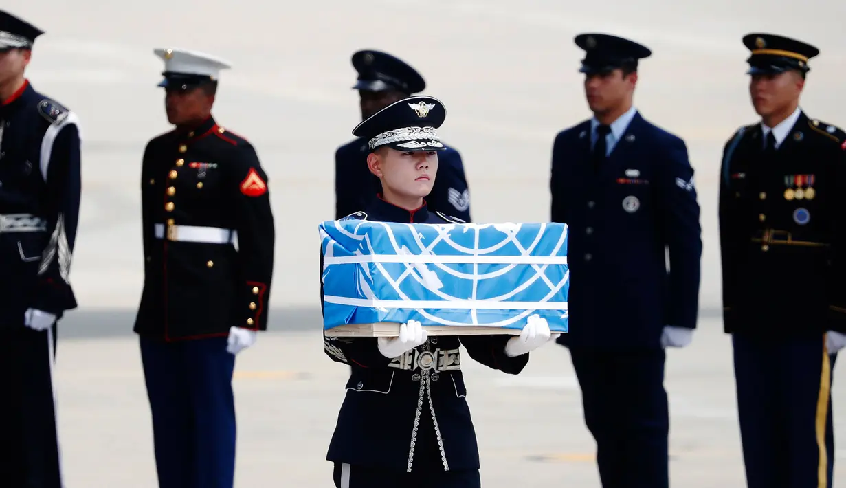 Pasukan PBB membawa kotak berisi jenazah yang diyakini sebagai tentara Amerika Serikat (AS) yang tewas selama Perang Korea pada tahun 1950-1953 di Pangkalan Udara Osan, Pyeongtaek, Korea Selatan, Jumat (27/7). (Kim Hong-Ji/Pool Photo via AP)