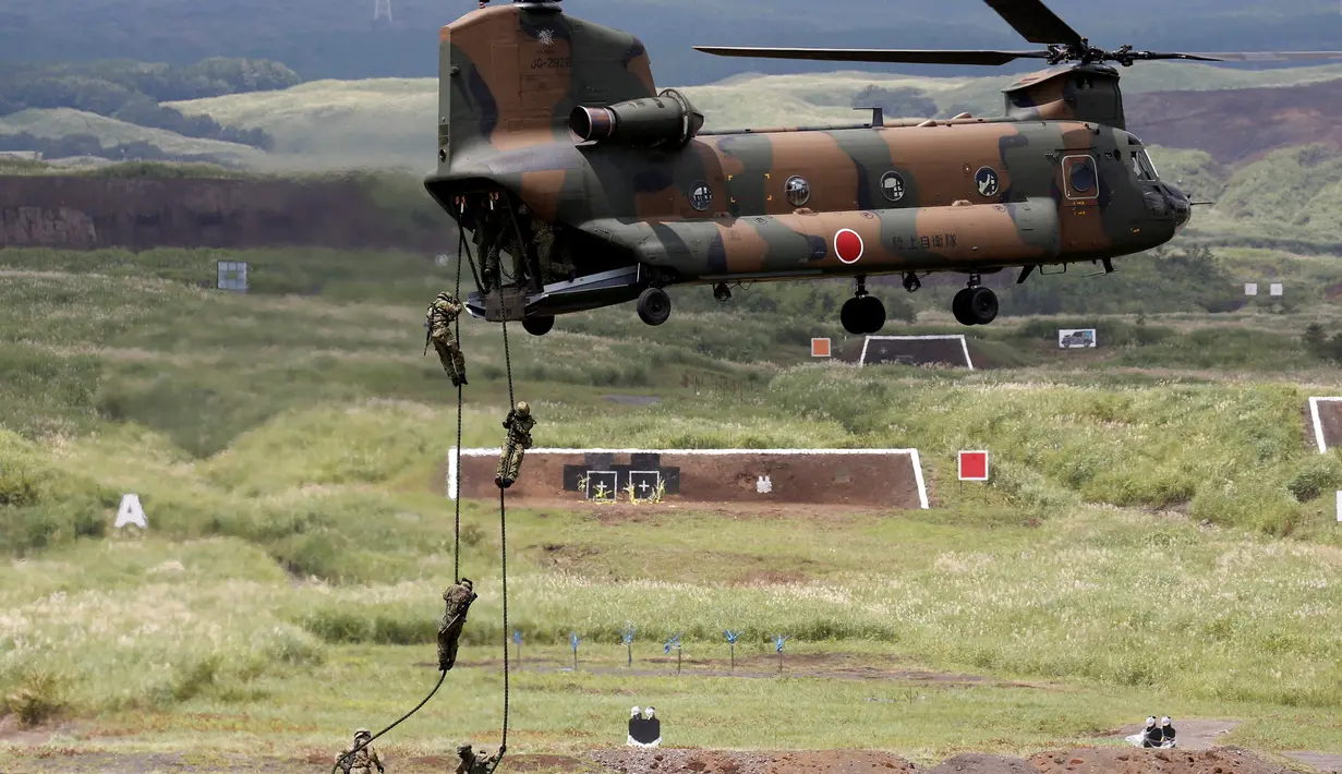 Tentara Self-Defense Force Jepang turun dari helikopter menggunakan tali selama sesi latihan tahunan di dekat Gunung Fuji di lapangan pelatihan Higashifuji di Gotemba, Tokyo, (25/08). (REUTERS / Kim Kyung-Hoon)