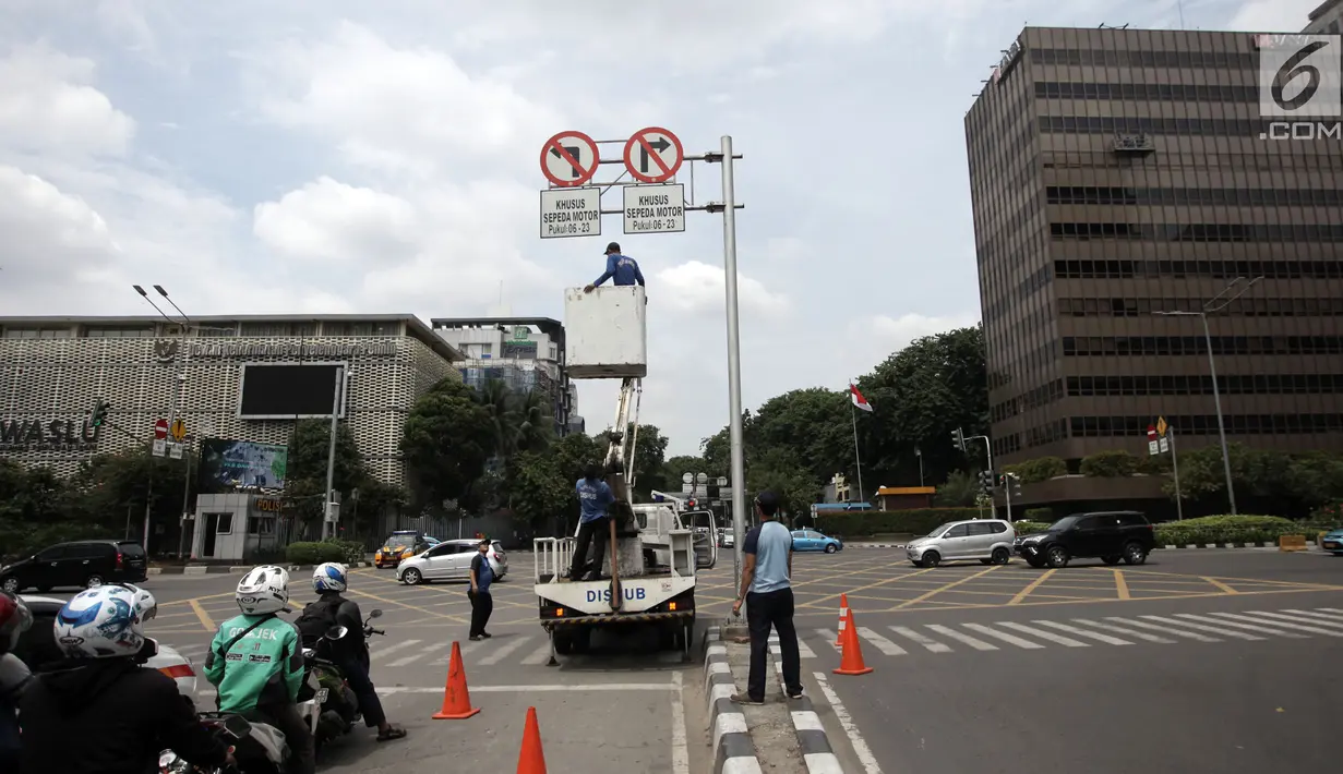 Petugas Dishub hendak menurunkan rambu larangan melintas untuk sepeda motor di kawasan Sarinah, Jakarta Pusat, Rabu (10/1). MA membatalkan Peraturan Gubernur Nomor 195 tahun 2014 tentang Pembatasan Lalu Lintas Sepeda Motor. (Liputan6.com/Arya Manggala)