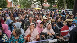 Penyaluran dikelola langsung oleh Yayasan Haji Muhammad Cheng Hoo Indonesia (YHMCHI). Tampak dalam foto, warga mengantre untuk menerima bantuan uang tunai di masjid Cheng Hoo, Surabaya, Jawa Timur pada Rabu 4 Maret 2026. (JUNI KRISWANTO/AFP)