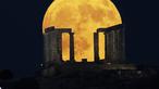 Bulan purnama terbesar atau supermoon muncul di belakang Kuil Poseidon di Tanjung Sounio, selatan Athena, Senin (19/8/2024). (AP Photo/Michael Varaklas)