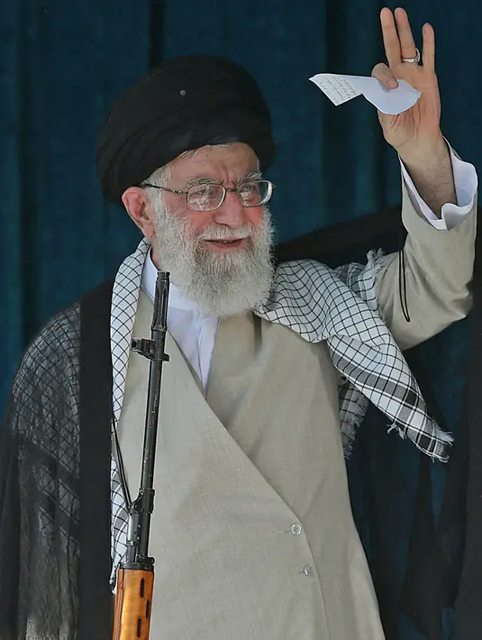 Pemimpin tertinggi Iran Ayatollah Ali Khamenei membawa senapan saat menyampaikan kutbah Idul Fitri di Imam Khomeini Mausoleum, Teheran, Rabu (5/6/2019). Khamenei mengatakan rencana perdamaian yang dirancang AS atas Palestina dan Israel pasti akan gagal. (HO/Iranian Supreme Leader's Website/AFP)