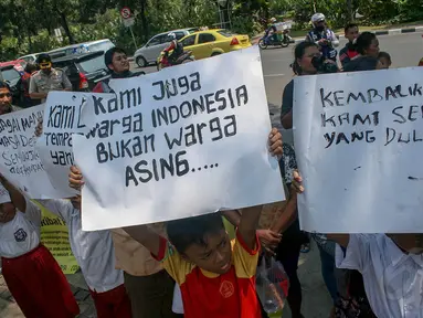 Sejumlah anak-anak berseragam sekolah beserta orangtuanya berdemo di depan Balai Kota, Jakarta, (22/9/14). (Liputan6.com/Faizal Fanani)