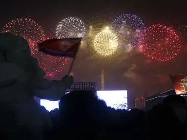 Warga menikmati pertunjukan Tahun Baru di Kim Il-sung Square, Pyongyang, Korea Utara, Sabtu (1/1/2022). Ratusan orang di Pyongyang berkumpul dengan mengenakan masker untuk menyaksikan pertunjukan kembang api menyambut Tahun Baru 2022. (AP Photo/Jon Chol Jin)
