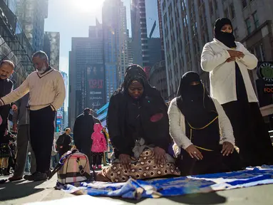 Sejumlah perempuan Muslim menunaikan salat dalam unjuk rasa mendukung Muslim Amerika dan aksi protes kebijakan imigrasi Presiden Donald Trump di Times Square, New York, Minggu (19/2). (AP/Andres Kudacki)