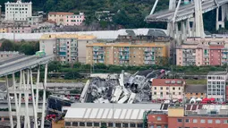 Sebuah truk berada di atas jembatan Morandi, dekat dengan bagian jalan layang yang runtuh, di Genoa, italia, Selasa (14/8). Jembatan ini memiliki tinggi 50 meter, termasuk menara penyangga, runtuh ketika 35 kendaraan berada di jembatan (AP/Antonio Calanni