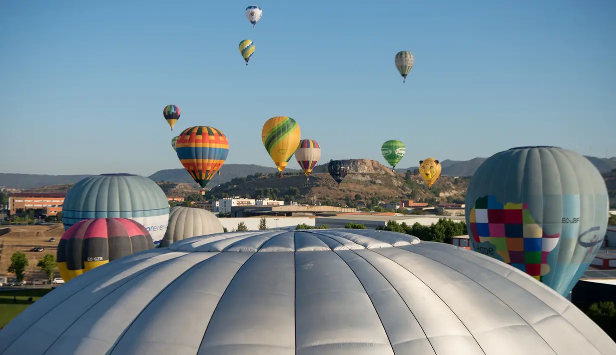 Puluhan balon udara terbang selama Festival Balon Eropa ke-23 di Igualada, Barcelona (11/7/2019). Festival Balon Eropa adalah yang terbesar di negara tersebut dan salah satu yang terbesar di Eropa. (AFP Photo/Josep Lago)