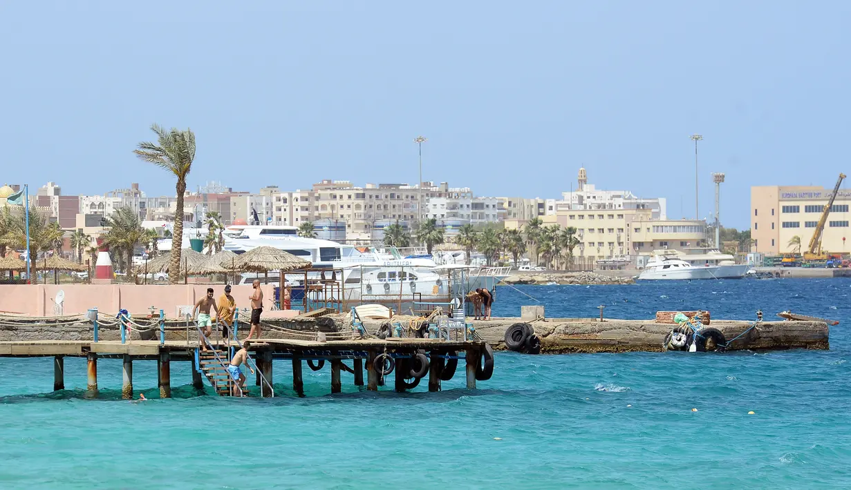 Sejumlah turis menyusuri tepi pantai di kota wisata Laut Merah Mesir, Hurghada pada 3 April 2019. Sepanjang tahun Hurghada beriklim tropis, sehingga banyak turis yang datang untuk merasakan musim panas dari bulan Januari sampai Desember. (Mohamed el-Shahed / AFP)