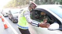 Polisi berbicara dengan pengendara mobil saat penyekatan di KM 31 Tol Jakarta-Cikampek, Kabupaten Bekasi, Jawa Barat, Sabtu (17/7/2021). Penyekatan dilakukan untuk mengantisipasi lonjakan lalu lintas jelang hari libur Idul Adha. (Liputan6.com/Herman Zakharia)