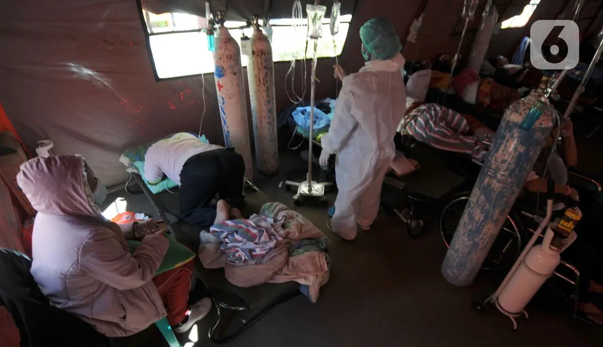 Pasien covid-19 bertelungkup karena kesulitan bernafas saat menjalani perawatan di dalam tenda darurat di RSUD Kota Bekasi, Jumat (25/06/2021). Puluhan pasien covid-19 saat ini dirawat dalam tenda darurat karena keterisian tempat tidur yang penuh akibat lonjakan kasus. (merdeka.com/Arie Basuki)