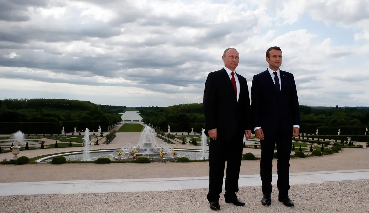 Presiden Prancis Emmanuel Macron dan Presiden Rusia, Vladimir Putin di taman Istana Versailles, dekat Paris, setelah pertemuan mereka, Senin (29/5). Macron bertemu tatap muka untuk pertama kalinya dengan Vladimir Putin. (AP Photo/Francois Mori, pool)