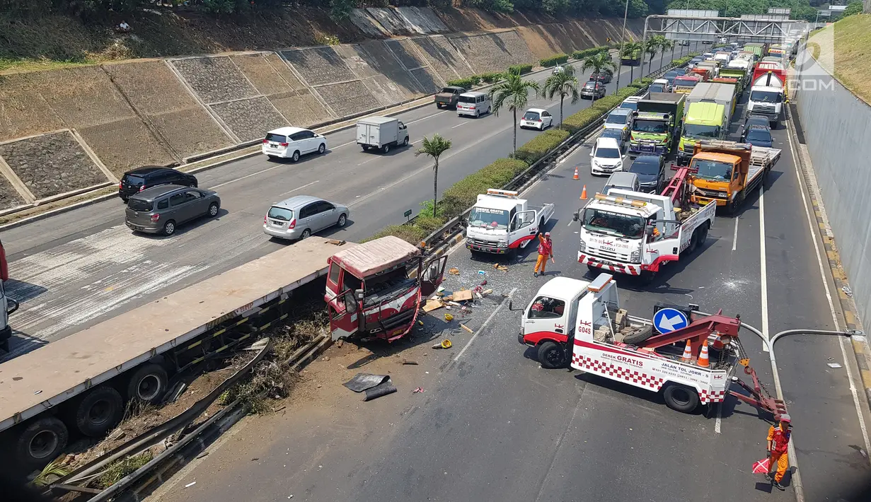Petugas mengatur arus lalu lintas usai terjadi kecelakaan truk trailer dengan minibus di Tol JORR TB Simatupang Km 29, Jakarta, Jumat (30/8/2019). Kijang Innova B 1466 GKI terlibat kecelakaan dengan truk trailer B 9843 SYL. (Liputan6.com/Herman Zakharia)
