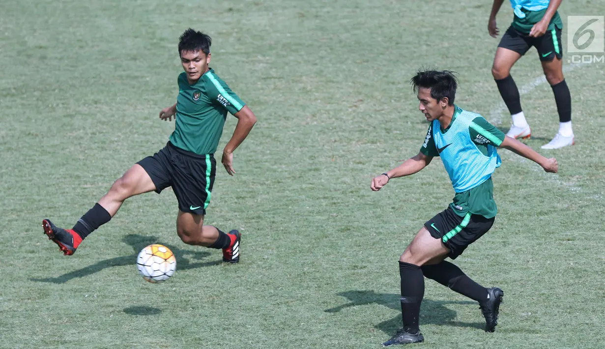 Pemain Timnas Indonesia U-19, Rachmat Irianto (kiri) berebut bola dengan rekannya saat latihan di Lapangan B Kompleks GBK, Jakarta, Selasa (18/9). Latihan ini persiapan  PSSI Anniversary Cup U-19 dan Piala AFC U19. (Liputan6.com/Helmi Fithriansyah)