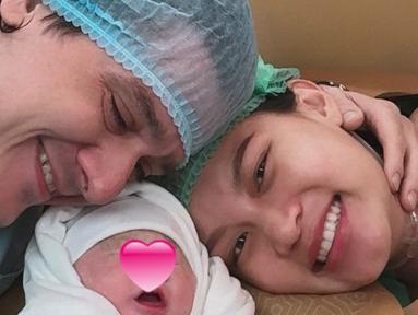 Patricia Gouw membagikan potret bahagia dirinya dan suami, Daniel Bertoli, ketika melihat sang buah hati sudah lahir ke dunia. Pasangan yang menikah pada Februari 2023 itu terlihat haru bahagia sambil mendekap baby Zoe yang sudah berpakaian hangat. (Liputan6.com/IG/@patriciagouw)