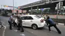 Warga mendorong mobil taksi yang menabrak tiang di Jalan Ahmad Yani, Jakarta, Rabu (1/8). (Merdeka.com/Iqbal Nugroho)