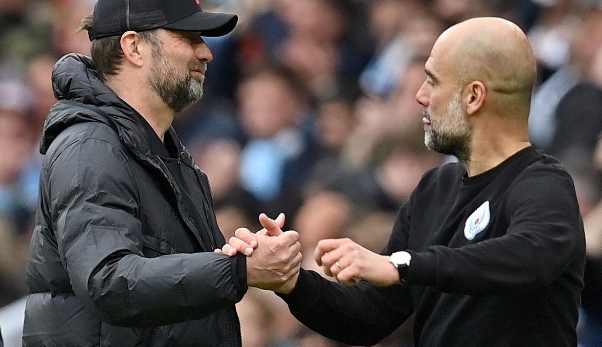Manajer Liverpool, Jurgen Klopp (kiri) berjabat tangan dengan manajer Manchester City, Pep Guardiola setelah pertandingan Liga Inggris antara Manchester City dan Liverpool di Etihad Stadium, 10 April 2022. (AFP/Paul Ellis)
