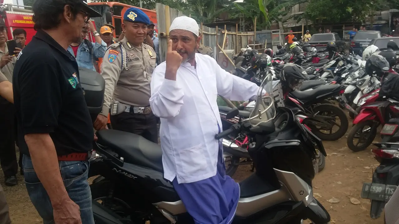 Pria bergamis putih dan bersarung itu tiba-tiba masuk di antara tamu undangan dan berteriak-teriak pada Ahok.