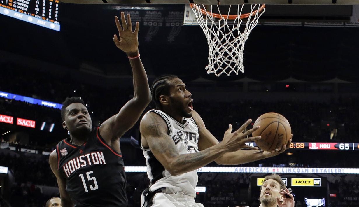 Pemain San Antonio Spurs, Kawhi Leonard (kanan) melakuka layup melewati adangan pemain Houston Rockets, Clint Capela  pada gim kelima NBA basketball playoff series di San Antonio, (9/5/2017). Spurs menang 110-107. (AP/Eric Gay)
