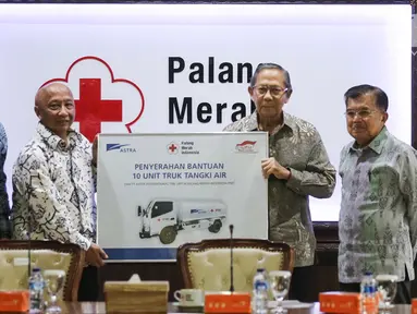 Plh Ketum PMI Ginandjar Kartasasmita memberikan penghargaan kepada Astra International yang diwakili Chief of Corcomm, Social Responsibility & Security Astra International Pongki Pamungkas di Kantor PMI, Jakarta, Jumat (8/2). (Liputan6.com/Fery Pradolo)