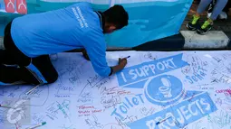Warga membubuhkan tanda tangan mendukung sosialisasi toliet sehat di Bundaran HI, Jakarta, Minggu (15/11/2015). Dalam acara tersebut tampil sebuah maskot berbentuk kotoran manusia yang membuat suasana semakin seru. (Liputan6.com/Yoppy Renato)