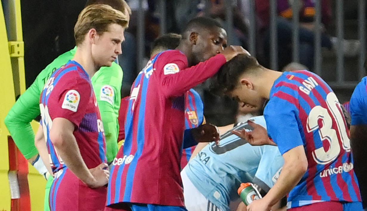 <p>Seusai benturan itu Gavi terlihat terbaring tak bergerak. Araujo masih terlihat bangkit dan mengejar bola. Namun, hanya beberapa langkah, ia kemudian kolaps dan tak sadarkan diri. (AFP/Lluis Gene)</p>