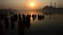 Umat Hindu India mengambil bagian dalam ritual pemujaan dewa matahari selama Festival Chhath Puja di tepi sungai Sabarmati, Ahmedabad, Selasa (13/11). Festival Hindu kuno ini dilakukan sebagai bentuk terima kasih kepada Dewa Matahari (SAM PANTHAKY/AF/AFP)