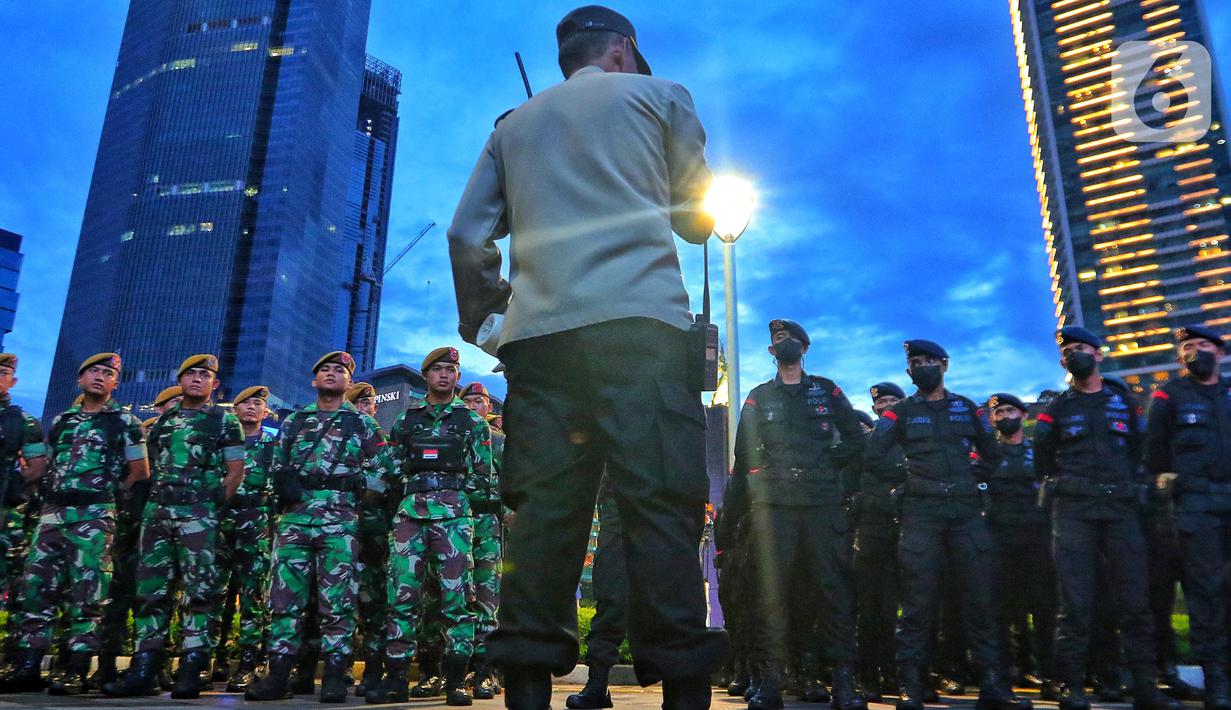 Personel gabungan TNI-Polri saat apel persiapan pengamanan perayaan malam Tahun Baru 2023 di Bundaran HI, Jakarta, Sabtu (31/12/2022). Petugas juga telah melakukan sterilisasi di kawasan Bundaran HI pada pukul 18.00 WIB dan ditutup secara permanen pada pukul 20.00 WIB. (Liputan6.com/Angga Yuniar)