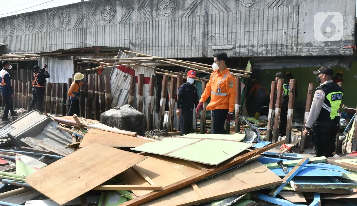 Sejumlah petugas gabungan dari Satpol pp ,KAI  dan Polisi membongkar bangunan lokalisasi liar Gunung Antang di Matraman, Jakarta Timur, Selasa (30/8/2022). Sebanyak 120 bangunan liar dibongkar di lahan seluas 2.500 meter persegi milik PT KAI dan selanjutnya akan dijadikan Ruang Terbuka Hijau (RTH). (Liputan6.com/Herman Zakharia)