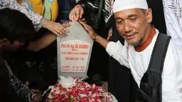 Seorang pria berswafoto dengan latar belakang batu nisan Presiden ketiga BJ Habibie di Taman Makam Pahlawan Nasional Kalibata, Jakarta, Kamis (12/9/2019). Selain berdoa, tidak sedikit juga warga  mengabadikan dengan kamera ponsel. (Liputan6.com/Herman Zakharia)