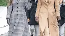 Ia tampil stylish kenakan turtleneck dan celana cokelat berbalut mantel panjang bermotif bunga. Ivanka lengkapi busananya dengan boots dan sarung tangan kulit [@oscardelarenta]
