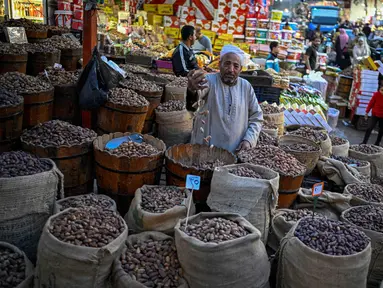 Penjual kurma menunggu pelanggan di pasar, distrik Sayyida Zeinab, pusat kota Kairo, pada Kamis 12 Februari 2026. Umat muslim di berbagai negara bersiap menyambut datangnya bulan suci Ramadan. (Khaled DESOUKI/AFP)