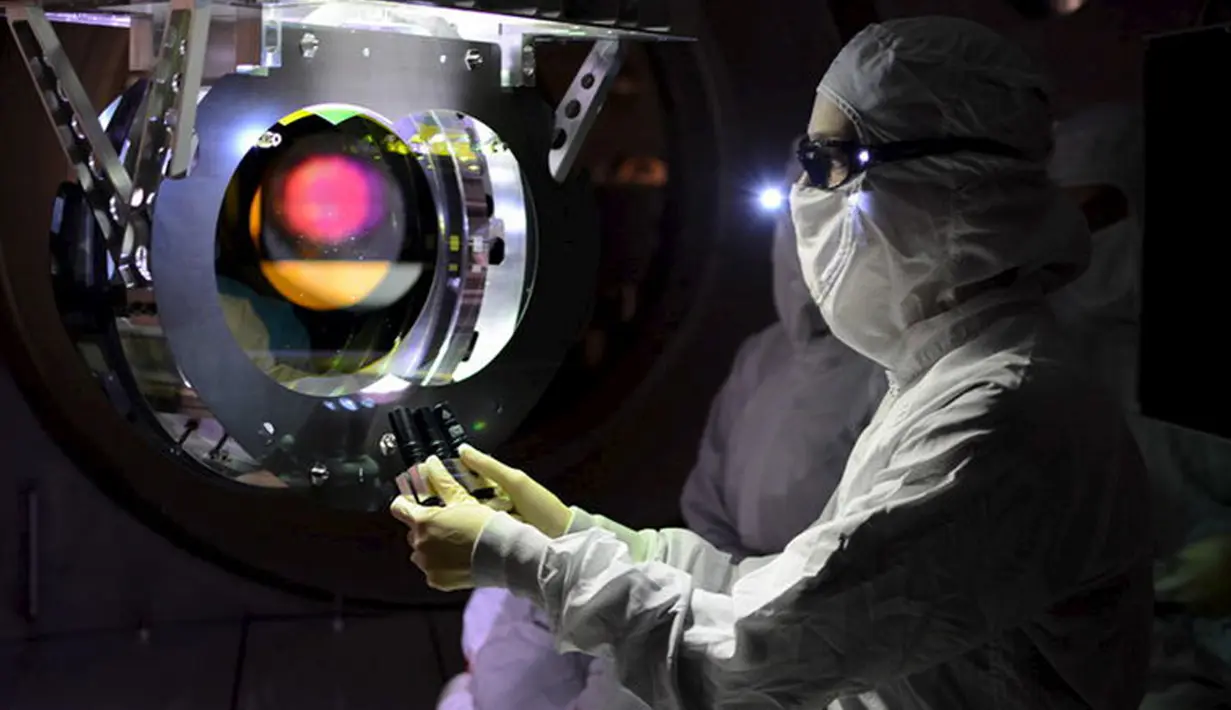 Peneliti saat memeriksa optik Laser Interferometer Gravitational -Wave Observatory  (LIGO), Washington, (8/2). Riak gravitasi dapat menimbulkan pergeseran dan peregangan antara bumi dan Pulsar atau bintang neutron. (REUTERS / Caltech)