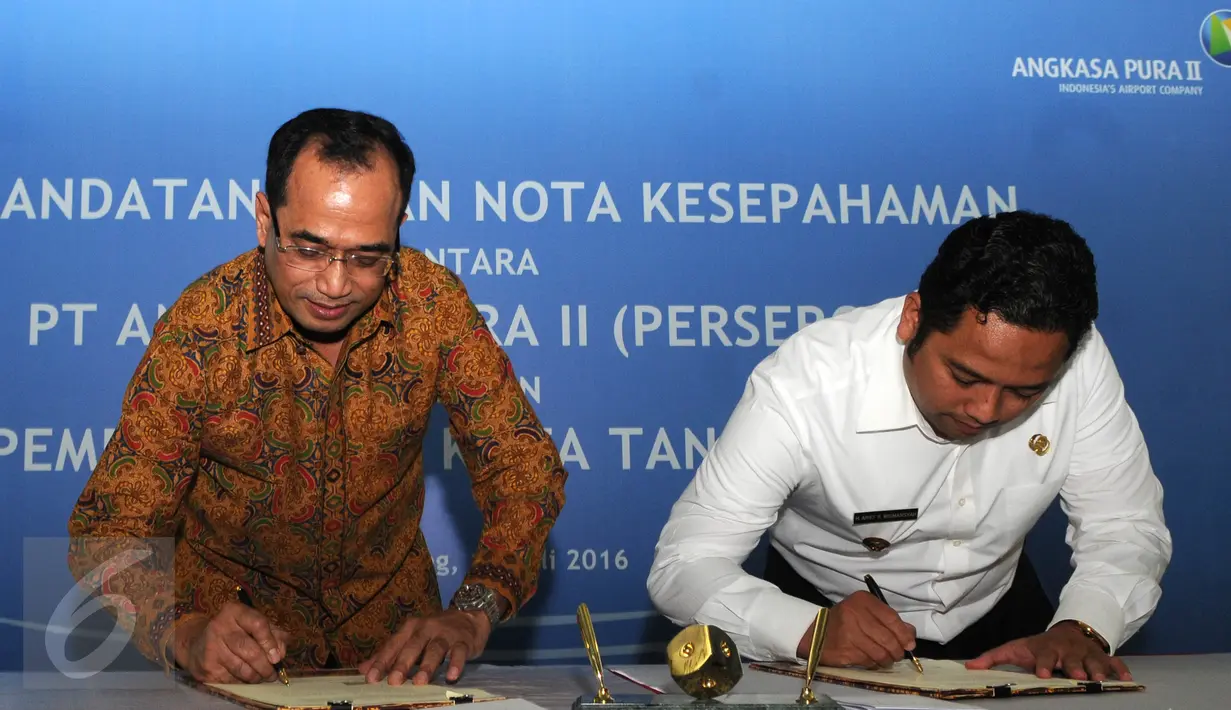 Presdir AP II, Budi Karya Sumadi (kiri) dan Walikota Tangerang Arief R Wismansyah menandatangani nota kesepahaman (MoU) mengenai suplai air bersih dan siap minum di Bandara Soekarno-Hatta, Tangerang, Rabu (13/7). (Liputan6.com/Helmi Affandi)