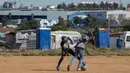 Anak-anak bermain sepak bola di Ramaphosa, Johannesburg, Afrika Selatan, Selasa (28/4/2020). Afrika Selatan akan mulai mengurangi penerapan lockdown ketat secara bertahap pada 1 Mei, meski kasus COVID-19 yang dikonfirmasi terus meningkat. (AP Photo/Themba Hadebe)
