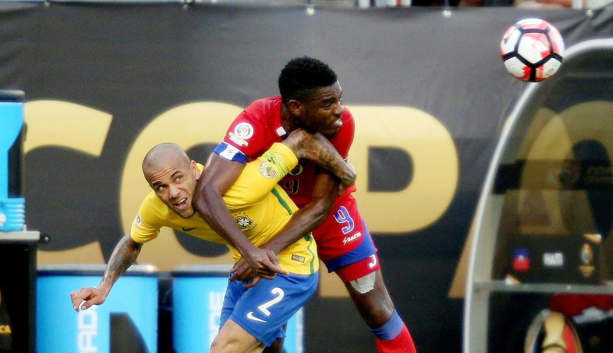 Pemain Brasil Dani Alves (kir) berebut bola dengan pemain Haiti, Kervens Belfort pada lanjutan  Copa America Centenario 2016 di Orlando, Florida, AS, (9/6/2016) WIB. (AFP/Gregg Newton)