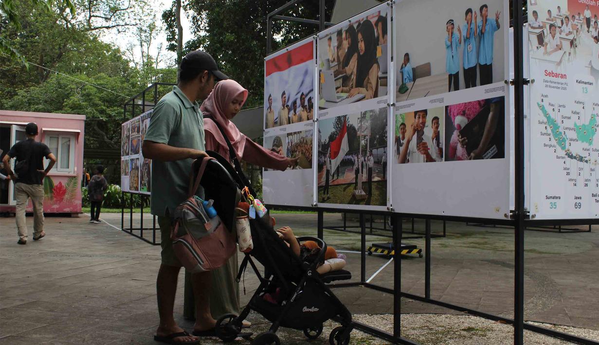 Melalui pameran ini, penyelenggara berupaya memberikan informasi mengenai kebijakan strategis pemerintah secara komprehensif dan mudah diakses masyarakat. Tampak dalam foto, pengunjung menyaksikan karya foto jurnalistik dalam pameran Haluan Merah Putih Roadshow yang digelar di Selasar Kantin Taman Margasatwa Ragunan, Jakarta Selatan, Rabu (24/12/2025). (merdeka.com/magang/Rendi Saputra)