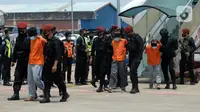 Anggota Densus 88 Antiteror menggiring terduga teroris saat tiba di Bandara Soekarno-Hatta, Tangerang, Banten, Kamis (18/3/2021). Polri memindahkan 22 terduga teroris jaringan kelompok Jamaah Islamiyah (JI) dari Jawa Timur ke Jakarta. (merdeka.com/Imam Buhori)