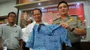 Kabid Humas Polda Metro Jaya, Kombes M. Iqbal memperlihatkan seragam milik FY, seorang supir taksi, di Jakarta, Rabu (23/3). FY ditangkap karena memposting pesan provokatif di media sosial Facebook saat demo taksi. (Liputan6.com/Faisal R Syam)