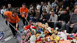 Sejumlah petugas mengumpulkan sejumlah boneka dilemparkan oleh para penonton sebelum laga lanjutan Euroleague Basketball 2024/2025 antara Partizan Belgrade melawan Maccabi Tel Aviv di Belgrade, Serbia, Jumat (03/01/2025) waktu setempat. (AFP/Oliver Bunic)