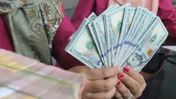Karyawan menunjukkan lembaran uang Dolar AS dan Rupiah di VIP Money Changer, Jakarta, Jumat (5/6/2026). (merdeka.com/Arie Basuki)